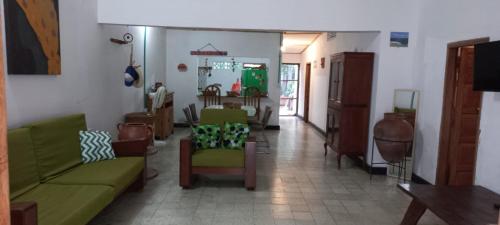 a living room with green couches and a room with a tv at Casa de playa en Dibulla in Dibulla