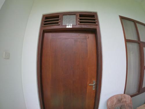 una porta di legno in un angolo di una stanza di New Star Light a Mirissa