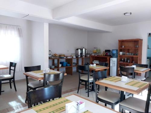 a dining room with tables and chairs and a kitchen at Urban Hotel in Federación