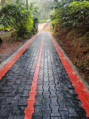 a cobblestone road with red and black at Green Land Estate Homestay 5 Rooms With Garden View in Madikeri