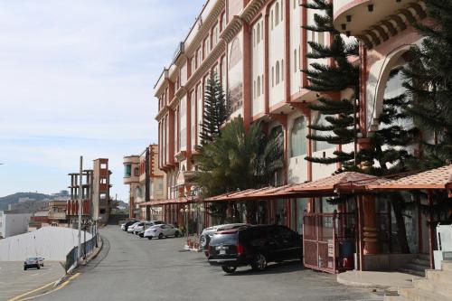 a street in a town with cars parked on the road at فندق الفالح للوحدات الفندقيه in Al Baha