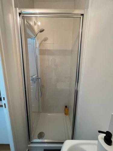 une douche avec une porte vitrée dans une salle de bain dans l'établissement Paris cocooning à 5 minutes de la Gare du Nord, à Paris