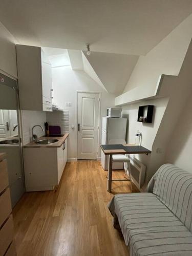 une petite cuisine avec un évier et une table dans l'établissement Paris cocooning à 5 minutes de la Gare du Nord, à Paris