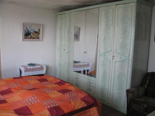 a bedroom with a bed and a large cabinet at Bungalow in Altglietzen für 2 Personen und 1 Kind bis 6 Jahren in Altglietzen