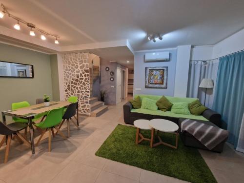 een woonkamer met een groene bank en een tafel bij Villa Paraiso-Luxury Villa with Heated Pool in Adeje