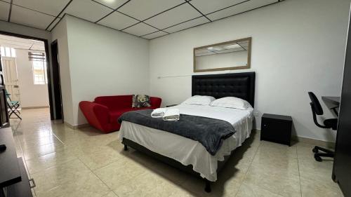 una camera con un letto e un divano rosso di Acogedor apartaestudio ubicado en la zona rosa de Pereira a Pereira