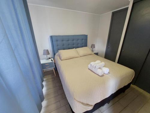 a bedroom with a bed with two towels on it at Apartamento Santiago Caupolicán in Santiago