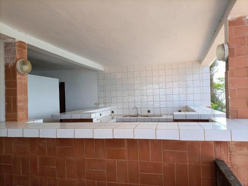 a large kitchen with two sinks and a large window at La coolitude in Toubab Dialaw
