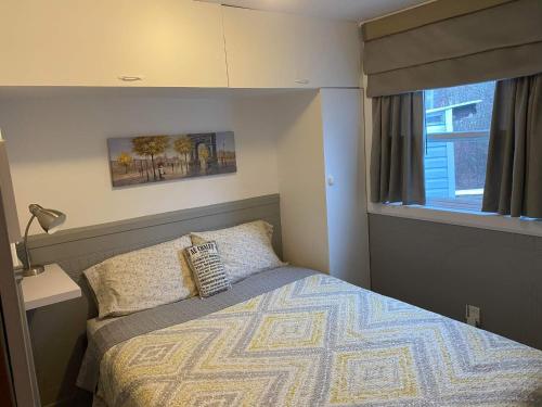 ein kleines Schlafzimmer mit einem Bett und einem Fenster in der Unterkunft Oasis du grand fond Inc in La Malbaie