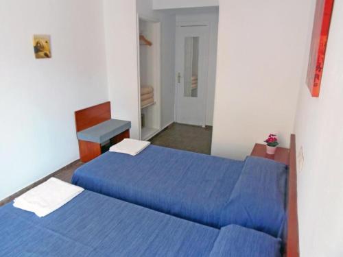 Sol de Mallorca في إل أرينال: سريرين في غرفة ذات أغطية زرقاء