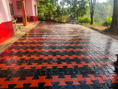 a cobblestone street with a red and black checkered floor at Green Land Estate Homestay 5 Rooms With Garden View in Madikeri