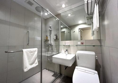 La salle de bains est pourvue de toilettes, d'un lavabo et d'une douche. dans l'établissement Smile Hotel Sapporo Susukino Minami, à Sapporo