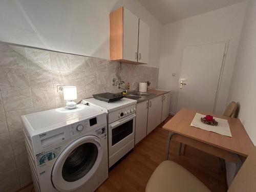 una cocina con lavadora y mesa en Apartman Butterfly, en Belgrado