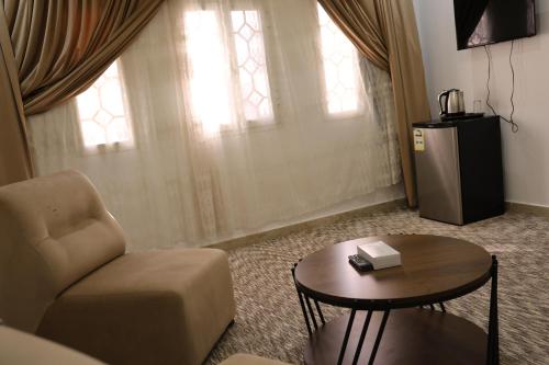 a living room with a chair and a table at فندق الفالح للوحدات الفندقيه in Al Baha