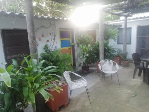 a patio with two chairs and some plants at Casa de playa en Dibulla in Dibulla