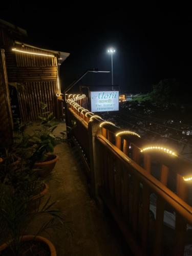 a lit up sign on a fence at night at Alohi The terrace Homestay in Tezpur