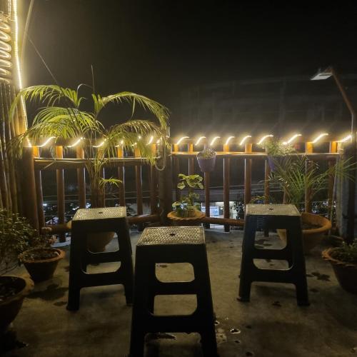 a patio with two chairs and lights on a fence at Alohi The terrace Homestay in Tezpur