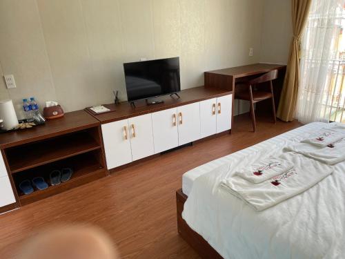 um quarto de hotel com duas camas e uma televisão de ecrã plano em Aurora's House em Dong Van