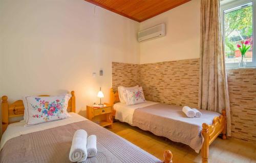 a bedroom with two beds and a window at Villa Melissa Paxos in Bogdanátika