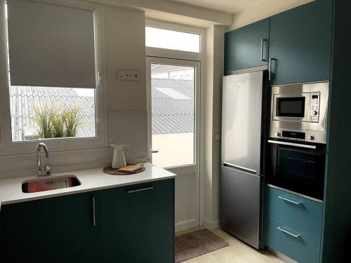 フェロルにあるPiso en el centro de Ferrol recién reformado.のキッチン(緑のキャビネット、シンク、窓付)