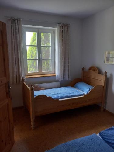 een slaapkamer met een houten bed en een raam bij Heideheimligkeit in Gelbensande