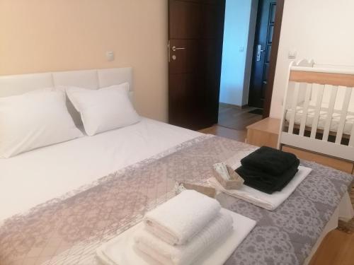 - une chambre avec un lit blanc et des serviettes dans l'établissement Danaya, à Petrich