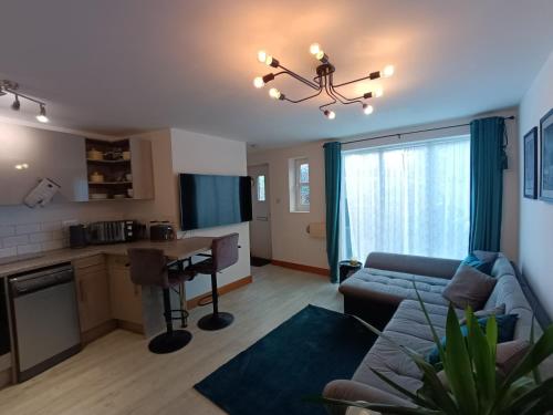 sala de estar con sofá y mesa en Entire modern cottage close to beach - Pet friendly en Gosport