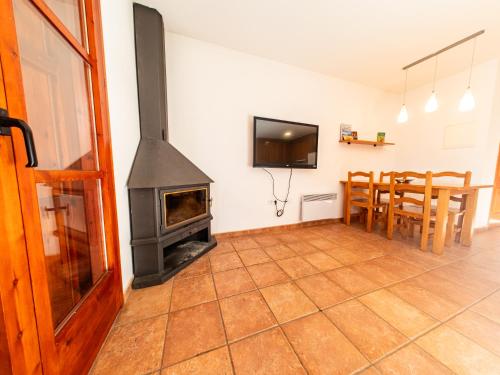 - un salon avec un poêle à bois et une salle à manger dans l'établissement Mountain Apartment: Pedraforca, à Saldes