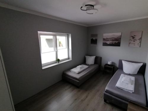 um quarto com uma cama, um sofá e uma janela em Ferienhaus Devilina mit Sauna am Harkebrügger See em Barßel