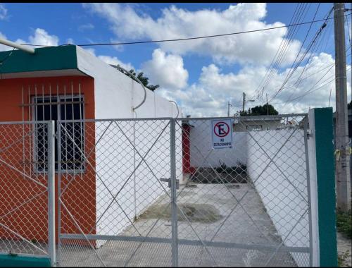 a fence in front of a building with a no parking sign at El Palacio Árabe in Mérida