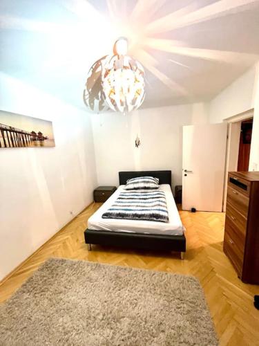 um quarto com uma cama e um lustre em Sporthalle Graz, Stadtpanorama em Graz