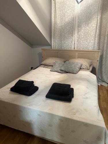 1 dormitorio con 1 cama con 2 toallas negras en Apartament z widokiem I, en Chełm