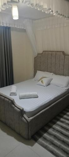 uma cama com um livro em cima em Tj homes-Airportview em Nairobi