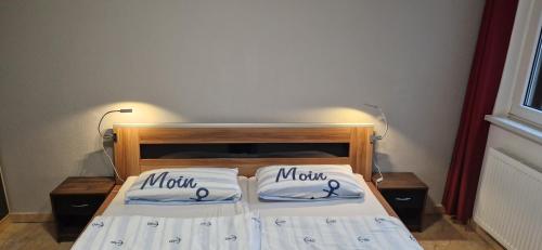 uma cama com duas almofadas com as palavras mãe sobre ela em FeWo Schwerin-Zippendorf mit Sauna und Strandnähe, 4 km bis zur City em Ostorfer Hals