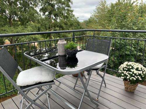 a white table and chairs on a balcony with trees at Landhaus Bachglück in Zülpich