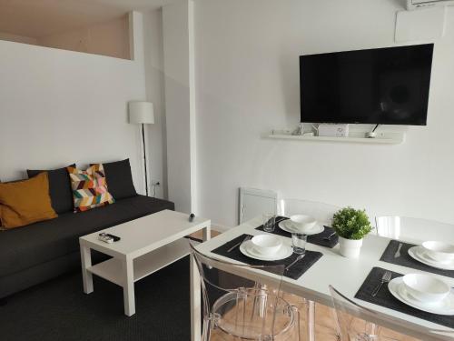 a living room with a couch and a table at San Centro IFEMA Wizink Metropolitano Airport Apartments in Madrid