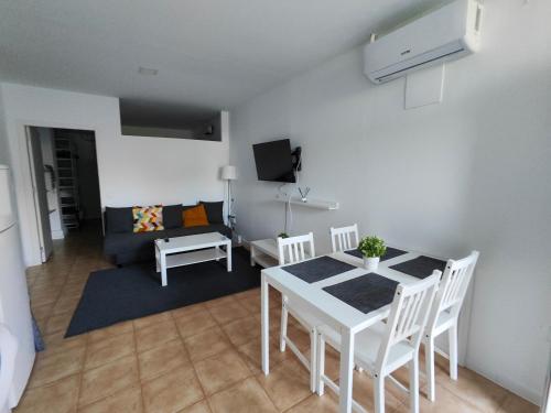 a living room with a table and chairs and a couch at San Centro Wizink IFEMA Metropolitano Airport Apartments in Madrid