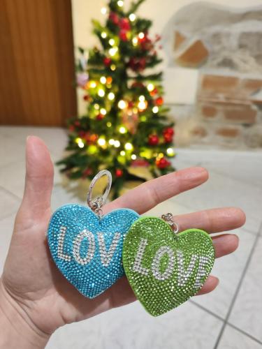 two heart earrings with the word joy in front of a christmas tree at Nalusa Home in Sarno