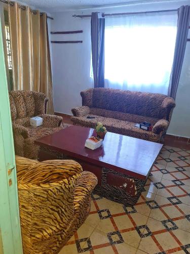 a living room with a table and a couch at Dala kwe in Siaya