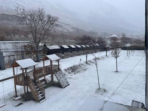 a snow covered yard with benches and a train at Boga Alpine Resort in Bogë
