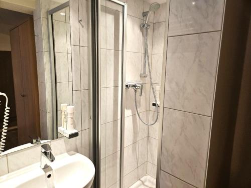 a bathroom with a shower and a sink at Gasthof-Pension Alt Kirchheim in Bad Kleinkirchheim