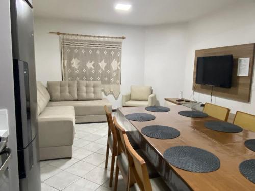 sala de estar con mesa y sofá en Casa Almeida e Moraes em Bombinhas Próximo a Praia, en Bombinhas