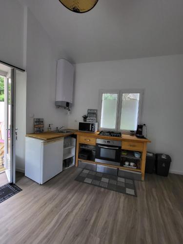 une cuisine avec une cuisinière et un comptoir dans l'établissement PETIT PARADIS, à La Bruffière