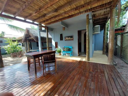 una terraza de madera con una mesa y una silla. en Taipu In House en Marau