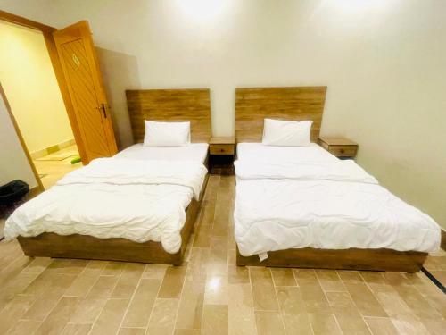 two beds in a small room with at Airport Hotel Bed & Rest in Karachi