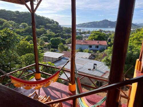 a hammock hanging from a building with a view at Buena Onda Backpackers in San Juan del Sur