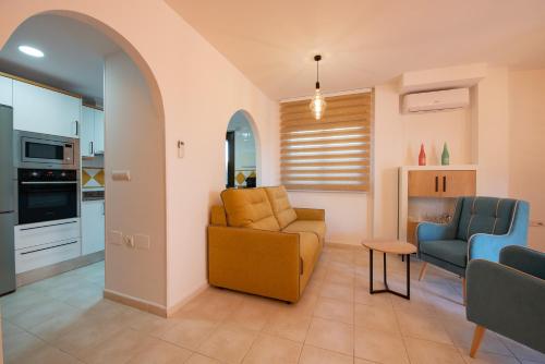 a living room with a couch and chairs and a kitchen at Holiday Beach El Olivo in Gran Alacant
