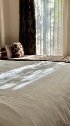 a close up of a white bed with a window at Alseides Boutique Hotel & Spa in Elatochori