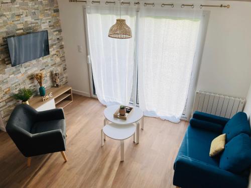 ein Wohnzimmer mit einem blauen Sofa und einem Tisch in der Unterkunft Le gîte de Mireloup in Plerguer