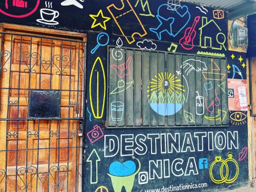 a wall covered in graffiti and drawings on it at Buena Onda Backpackers in San Juan del Sur